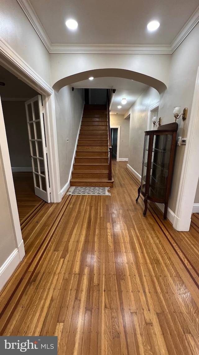 hallway featuring ornamental molding and hardwood / wood-style floors