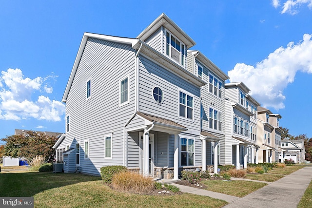 townhome / multi-family property featuring a front yard and central AC