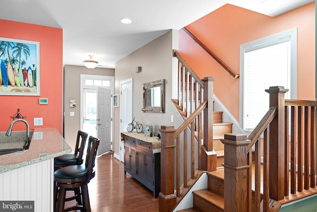 stairs featuring hardwood / wood-style floors and sink