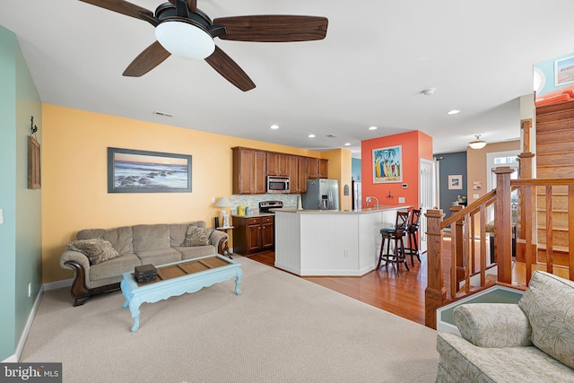 carpeted living room with ceiling fan