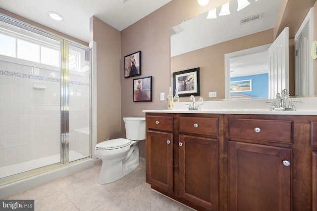 bathroom featuring tile patterned floors, vanity, toilet, and walk in shower