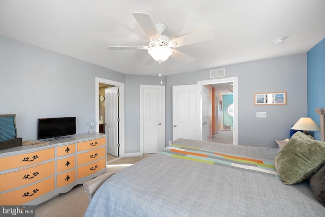 bedroom featuring ensuite bath, ceiling fan, and light colored carpet