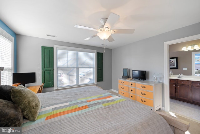 bedroom featuring connected bathroom, ceiling fan, sink, and light colored carpet