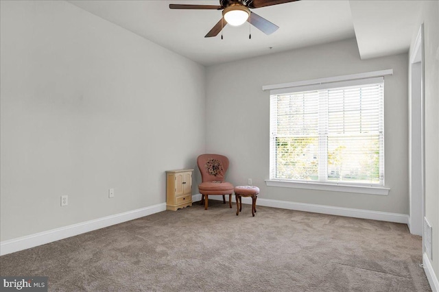 living area featuring light colored carpet and ceiling fan