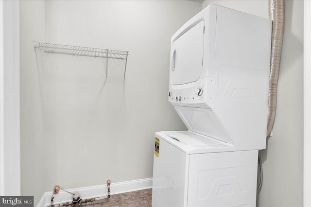 clothes washing area featuring stacked washer and clothes dryer and light tile patterned floors