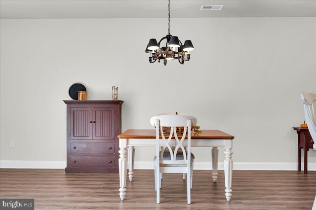 dining area featuring an inviting chandelier and hardwood / wood-style floors