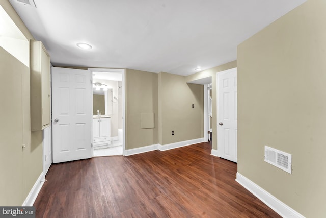 basement with sink and dark hardwood / wood-style flooring