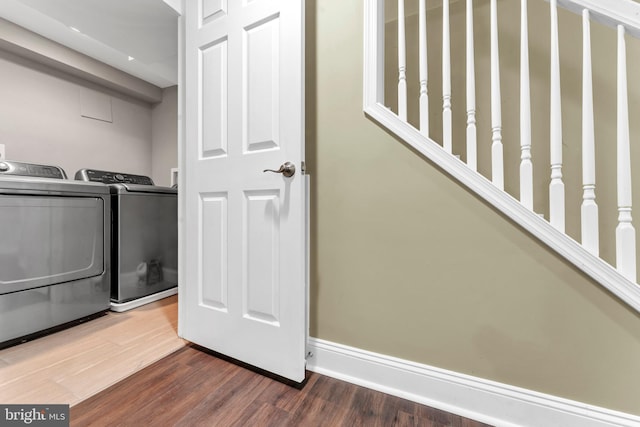 washroom with dark wood-type flooring and washing machine and clothes dryer