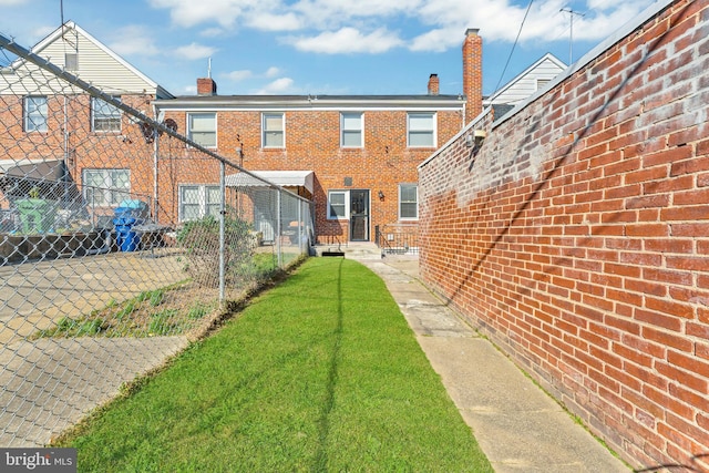 rear view of house featuring a lawn