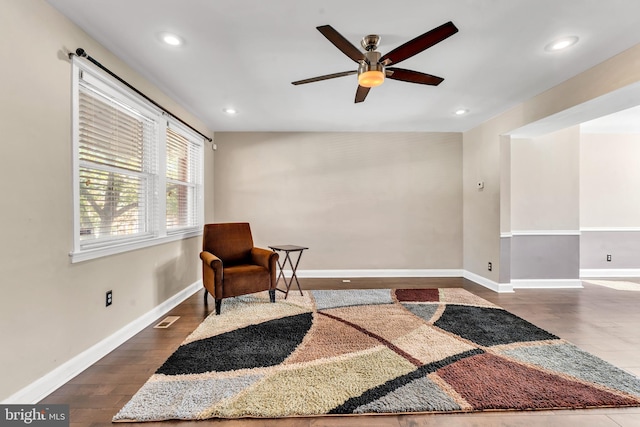 sitting room featuring dark wood-type flooring and ceiling fan