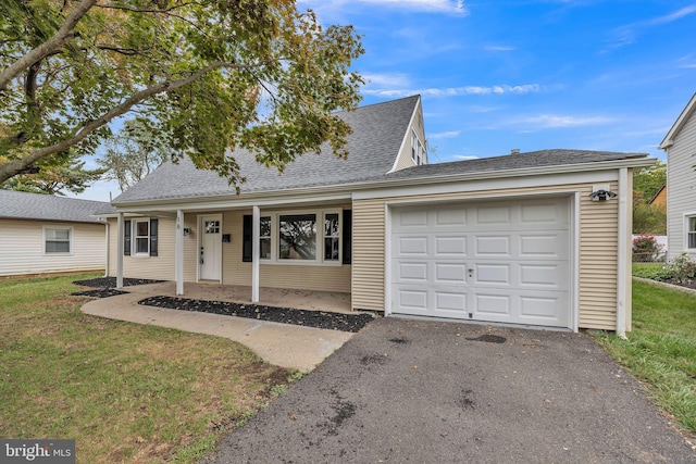 view of front of home with covered porch, a garage, and a front yard