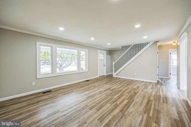 unfurnished living room featuring ornamental molding and light hardwood / wood-style flooring