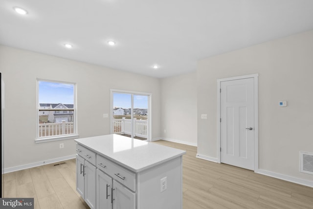 kitchen with a kitchen island and light hardwood / wood-style flooring