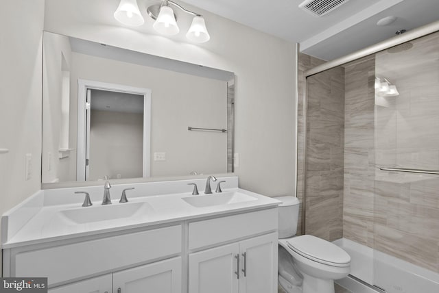 bathroom featuring toilet, a shower with door, and vanity