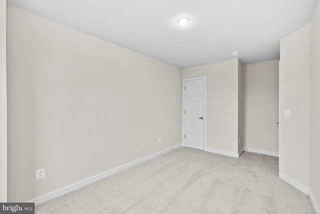 unfurnished room featuring light carpet