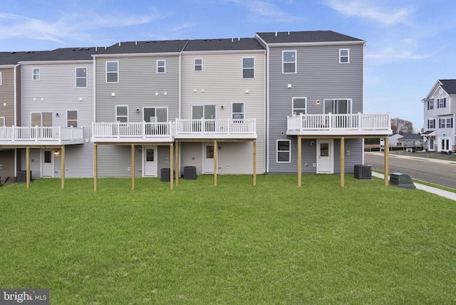 rear view of property featuring central air condition unit and a yard