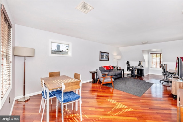 dining space with wood-type flooring