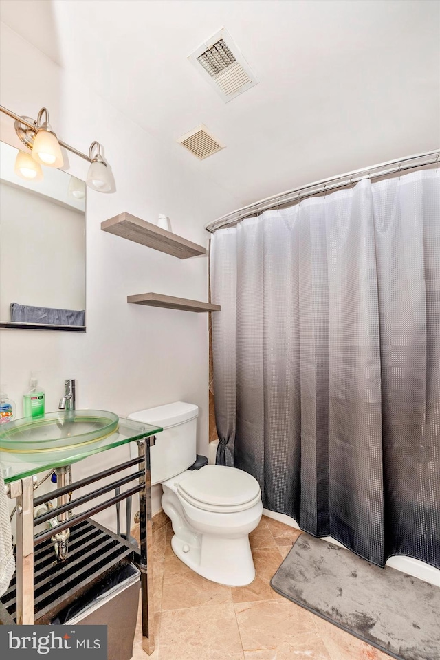 bathroom featuring toilet, vanity, and tile patterned floors