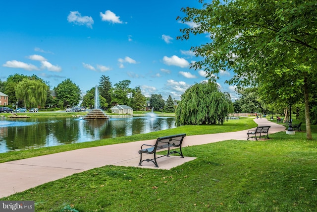 view of property's community with a water view and a yard