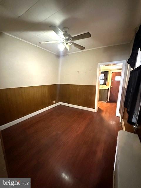 spare room with wood walls, hardwood / wood-style floors, and ceiling fan