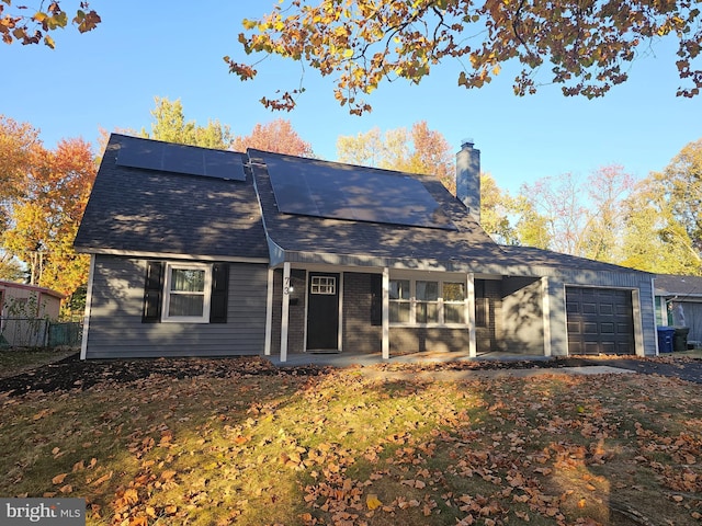73 Genesee Ln, Willingboro, NJ 08046 - view of front of property featuring fence, solar panels, an attached garage, and a chimney