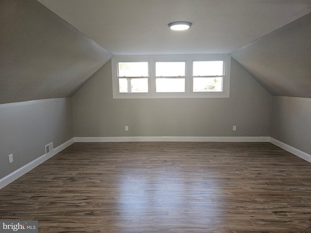 bonus room featuring lofted ceiling, dark hardwood / wood-style floors, and plenty of natural light