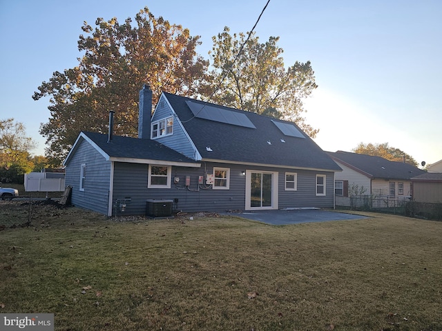 rear view of property featuring a patio, central AC unit, and a lawn