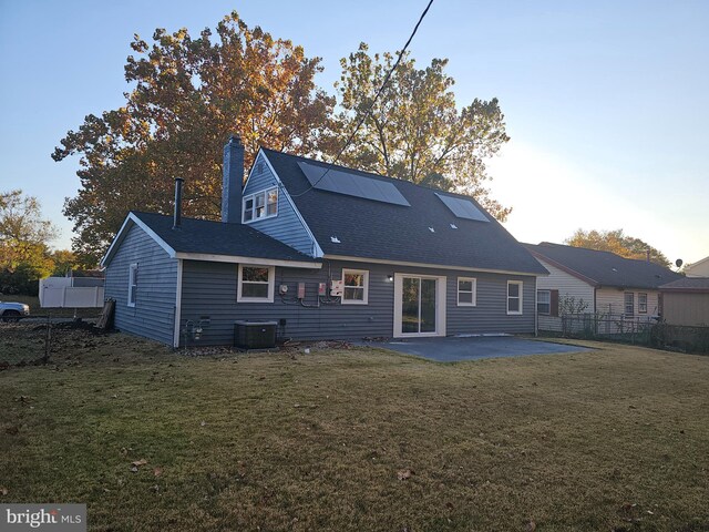 73 Genesee Ln, Willingboro, NJ 08046 - back of house with roof mounted solar panels, a yard, central air condition unit, and a patio
