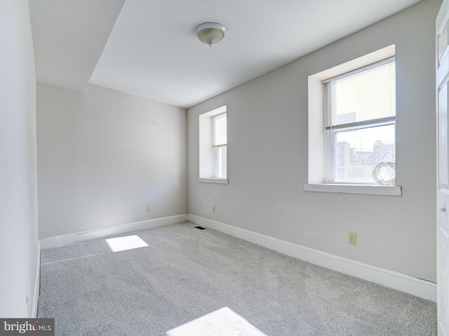 spare room featuring a healthy amount of sunlight and light colored carpet