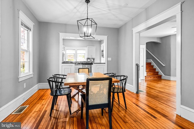 dining space featuring light hardwood / wood-style flooring and a chandelier