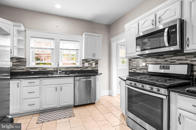 kitchen featuring appliances with stainless steel finishes, sink, decorative backsplash, and white cabinets