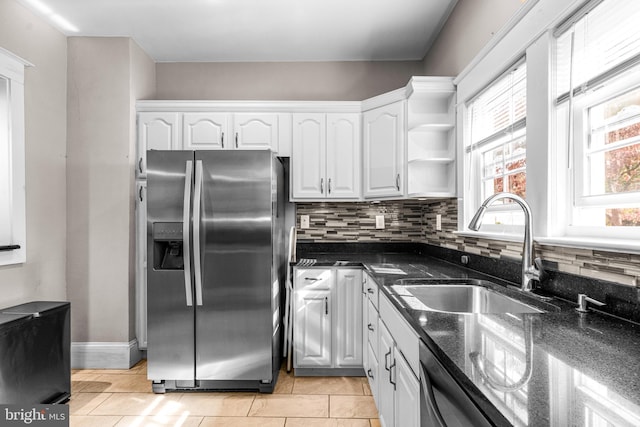 kitchen featuring backsplash, dark stone counters, sink, white cabinets, and appliances with stainless steel finishes