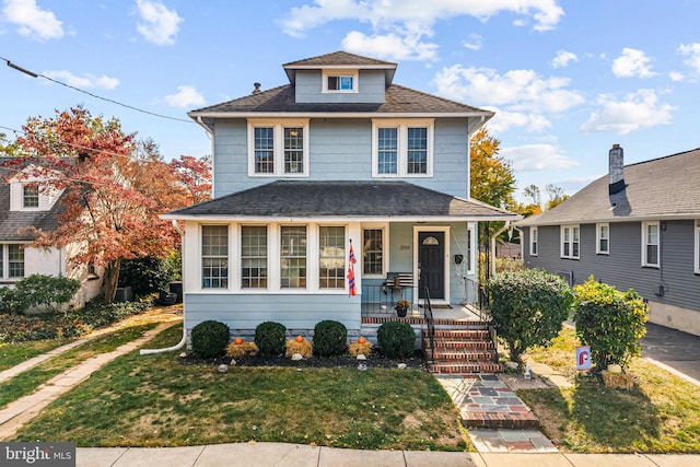 view of property featuring a front lawn and covered porch