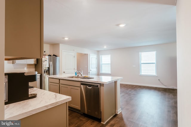 kitchen with dark wood-type flooring, stainless steel appliances, sink, and a center island with sink