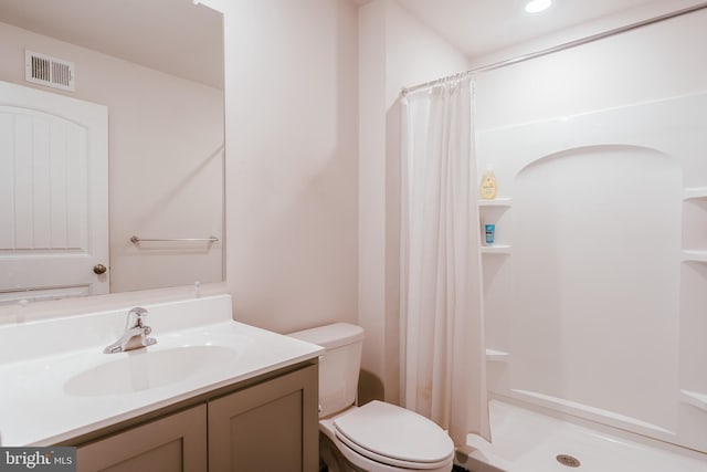 bathroom with vanity, toilet, and curtained shower