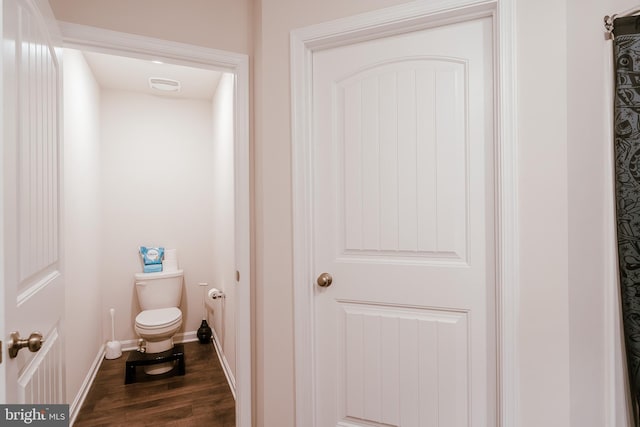 bathroom featuring wood-type flooring and toilet