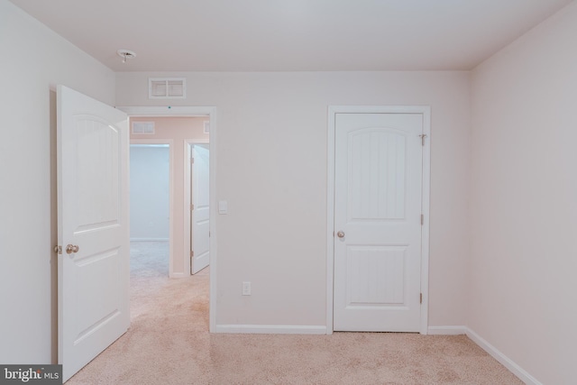 unfurnished bedroom featuring light carpet