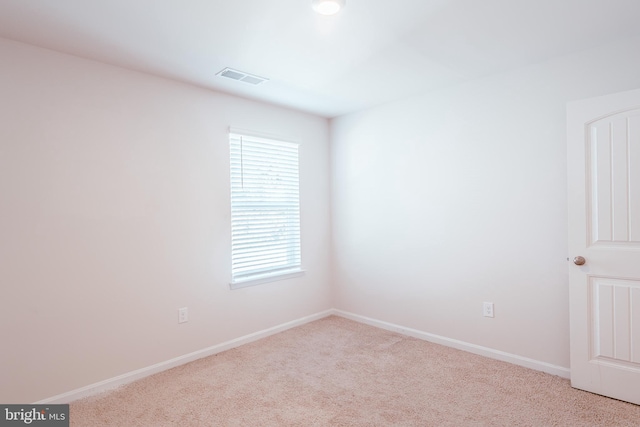 unfurnished room featuring light carpet