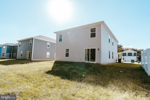 rear view of property featuring a lawn