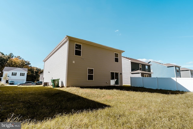 back of property featuring central AC and a yard