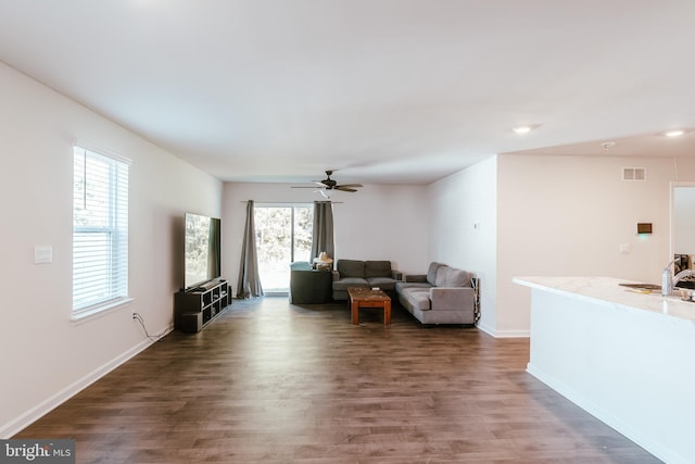 living room with dark hardwood / wood-style floors, a healthy amount of sunlight, and ceiling fan