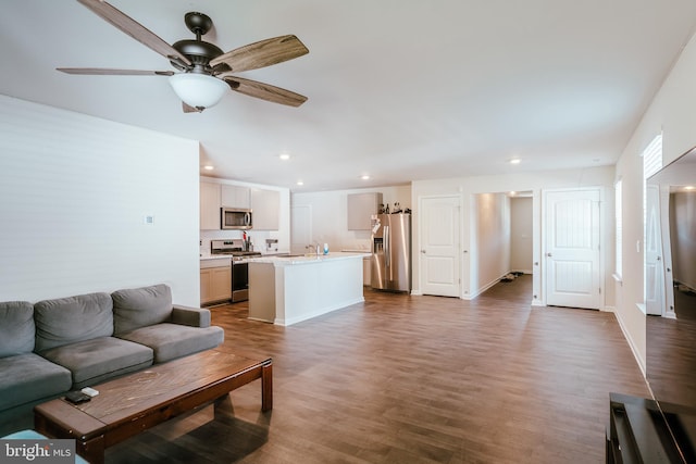 living room with sink, ceiling fan, and dark hardwood / wood-style flooring