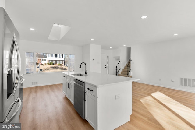 kitchen featuring visible vents, stainless steel appliances, a sink, and open floor plan