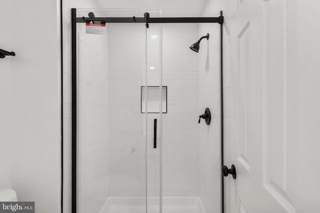 bathroom featuring a shower stall and toilet