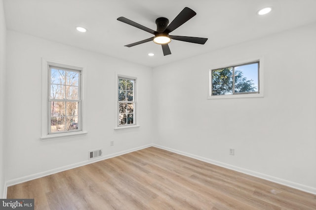 spare room featuring light wood-type flooring, baseboards, visible vents, and recessed lighting