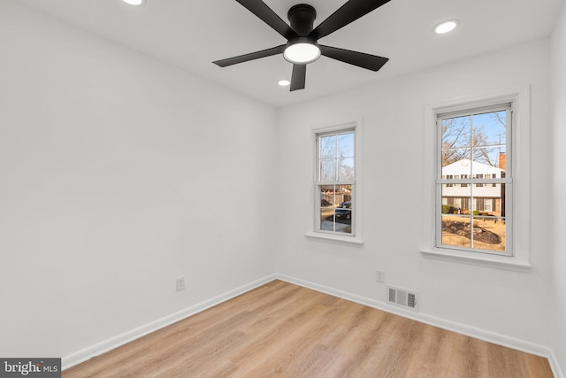 spare room with a healthy amount of sunlight, light wood-style floors, baseboards, and recessed lighting