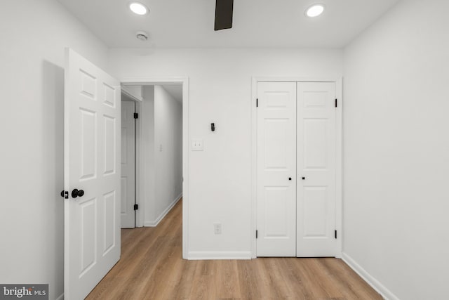 unfurnished bedroom featuring light wood-style floors, recessed lighting, a closet, and baseboards