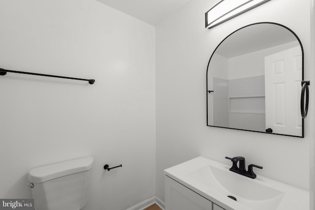 bathroom featuring vanity, toilet, and baseboards