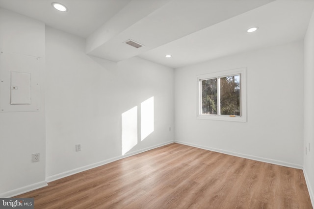 unfurnished room with recessed lighting, visible vents, baseboards, light wood-style floors, and electric panel