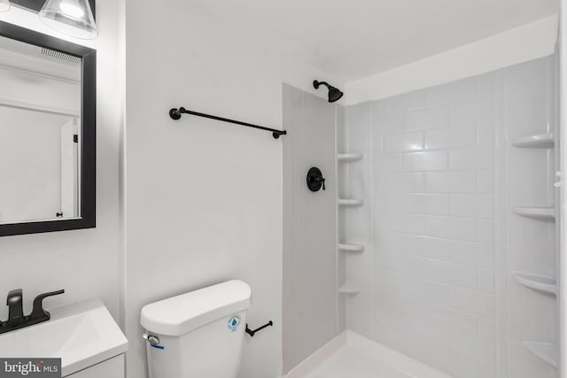 bathroom featuring a shower, vanity, and toilet